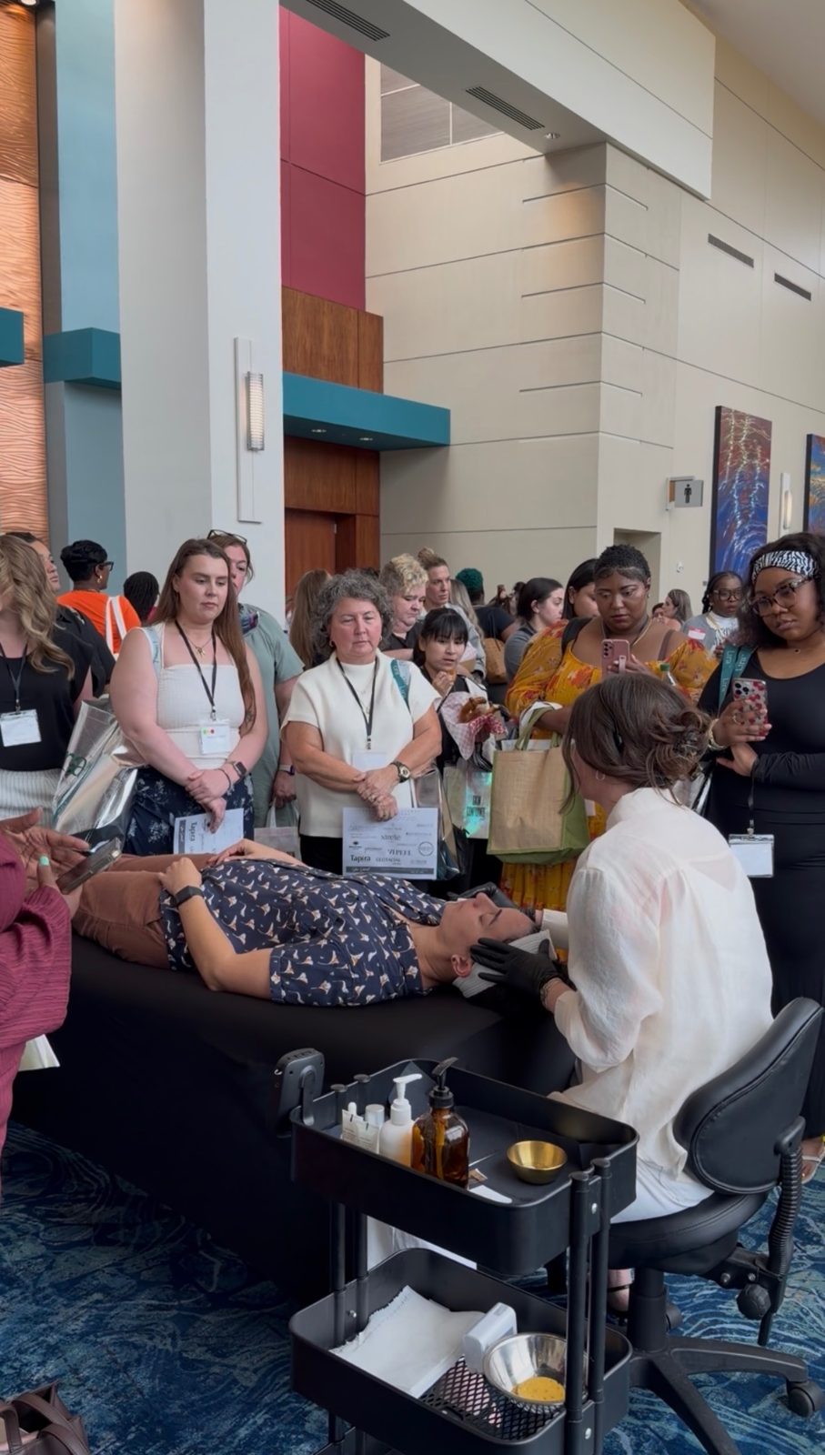 Kelly Temple demonstrating a live facial for a crowd of estheticians