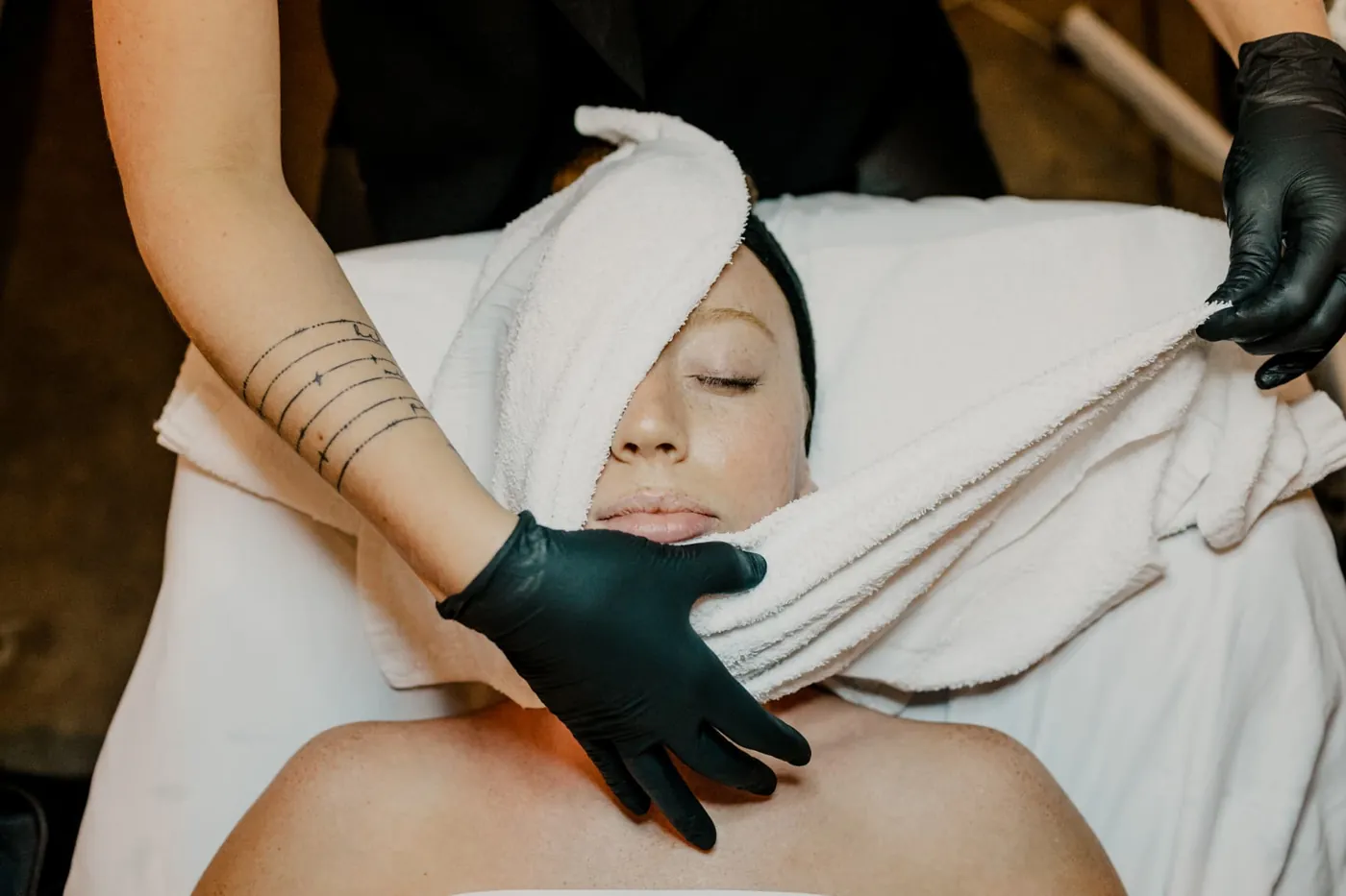 Client relaxing under warm towels during a facial at TEMPLE day spa in Savannah