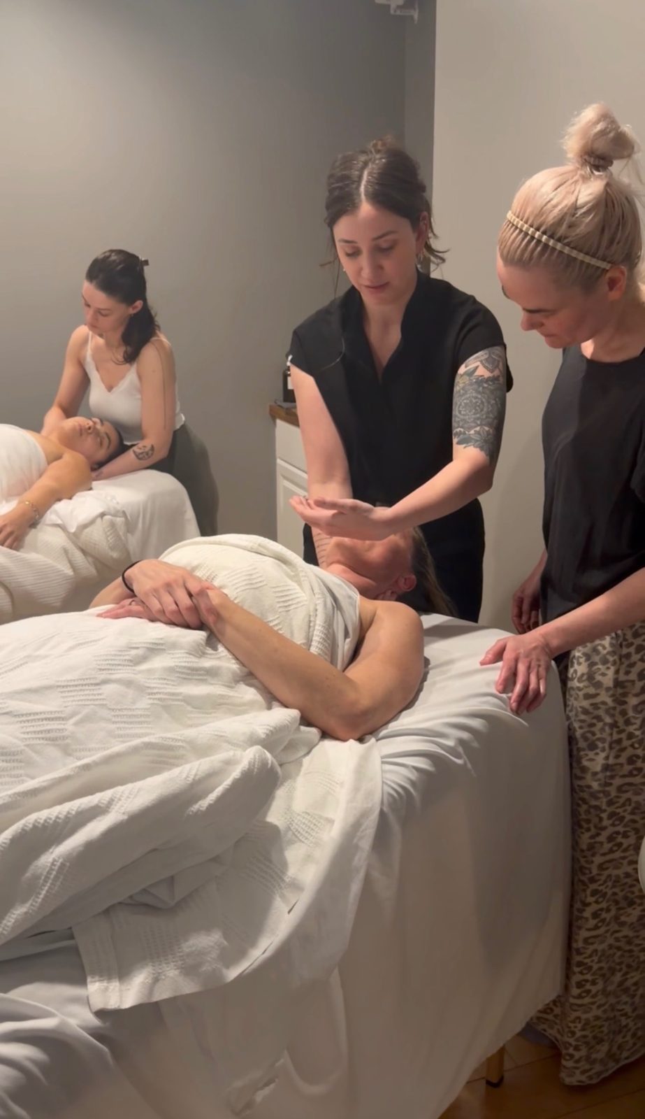 Kelly Temple guiding an esthetician's hands through a facial technique during a one-on-one mentoring day