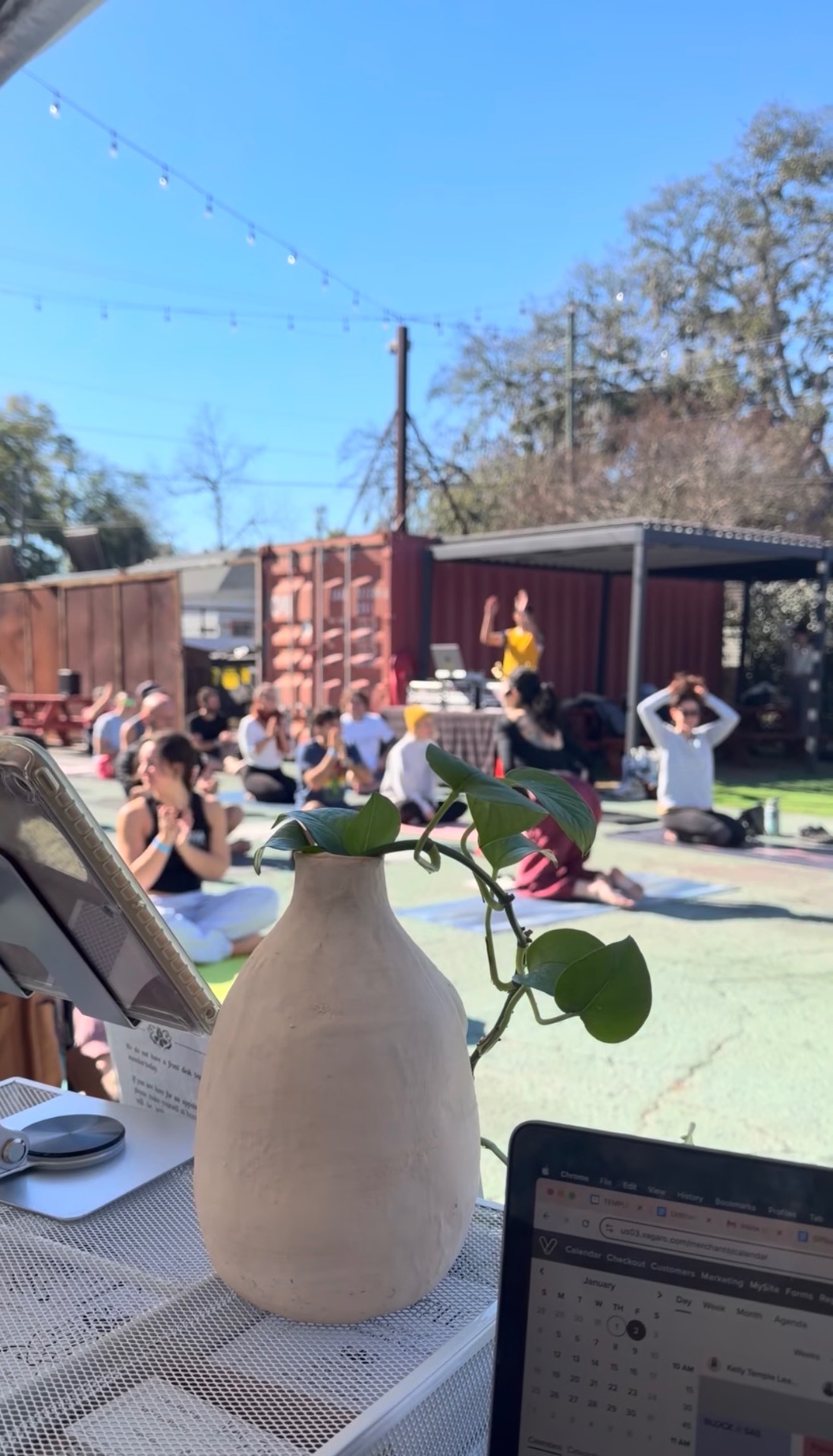 Guests at an outdoor wellness gathering seen from the TEMPLE check-in table