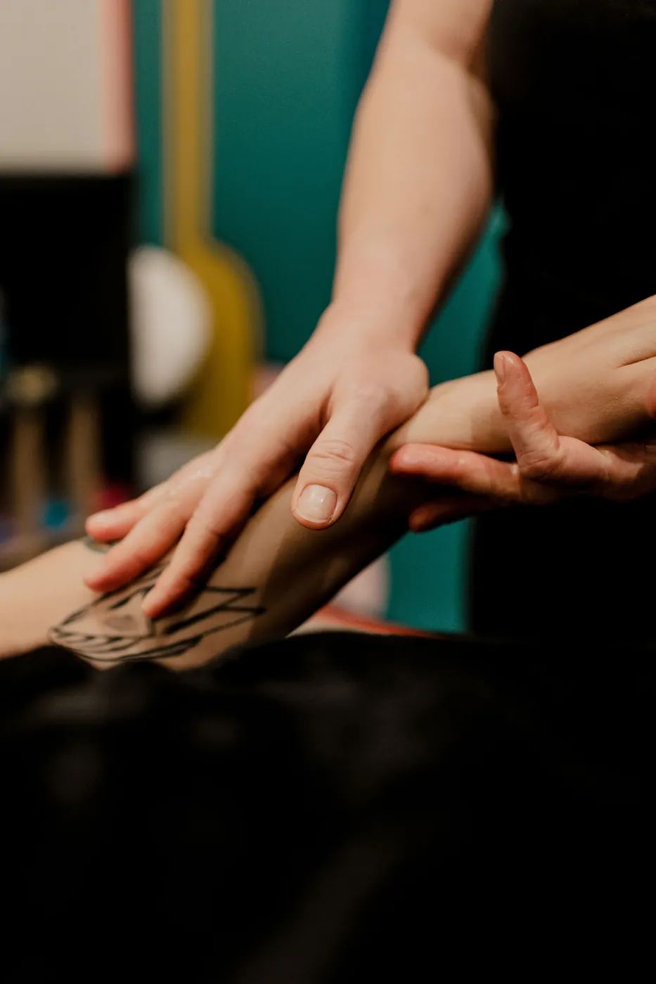 Therapist's hands working oil into a client's arm during a massage at TEMPLE in Savannah