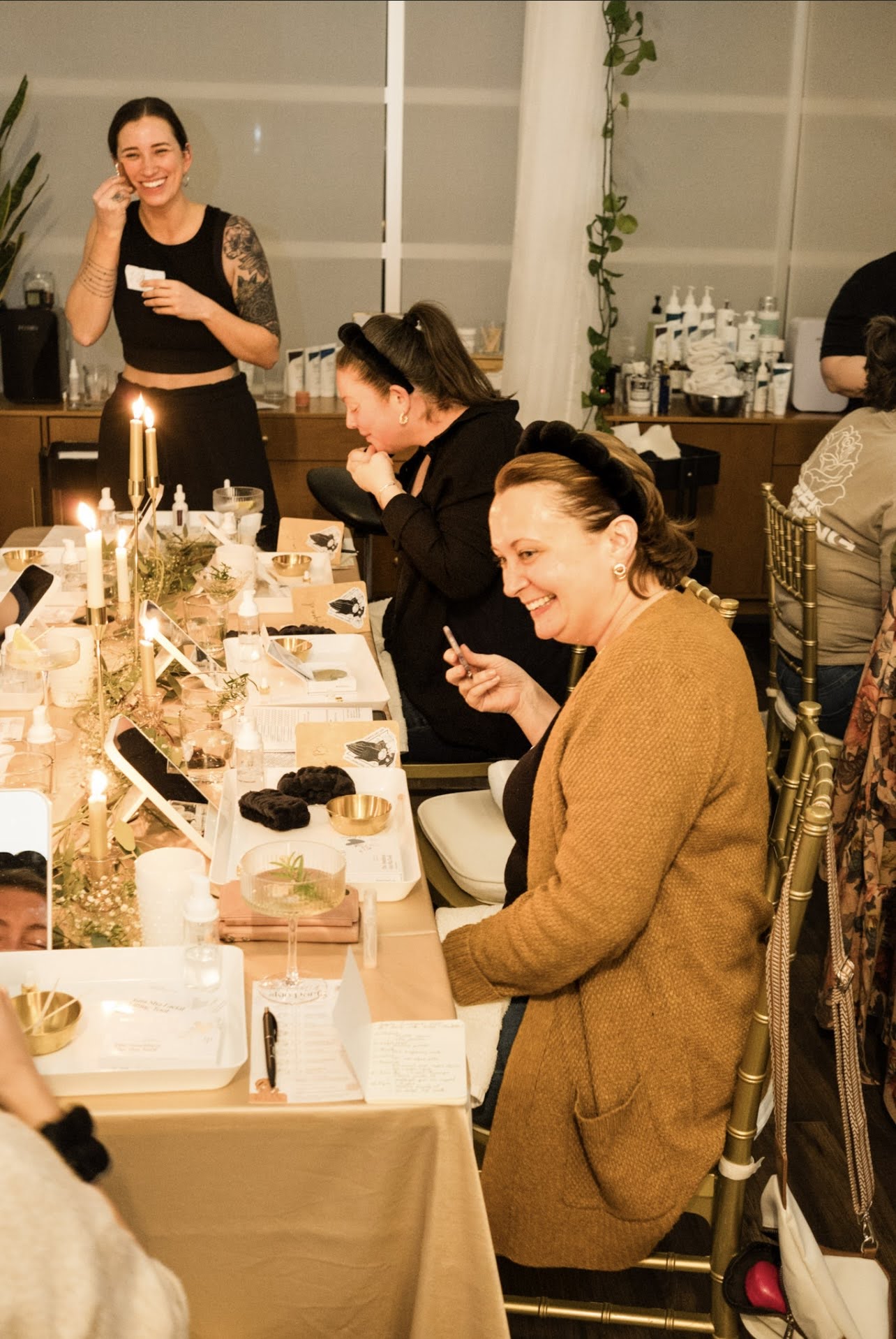 Kelly Temple leading guests through their Skin Party facial routine at a candlelit table